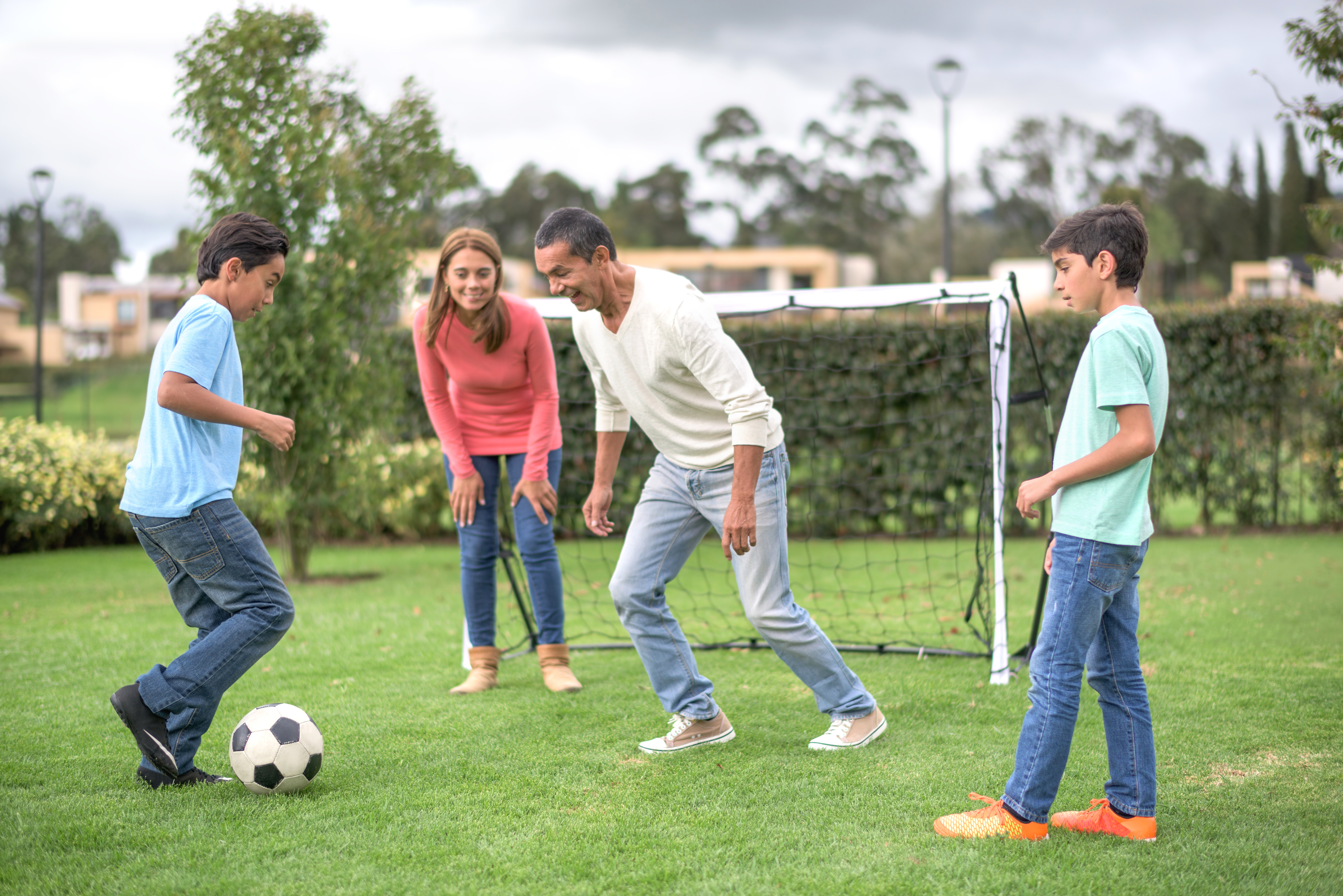 Dad with kids playing soccer at the park